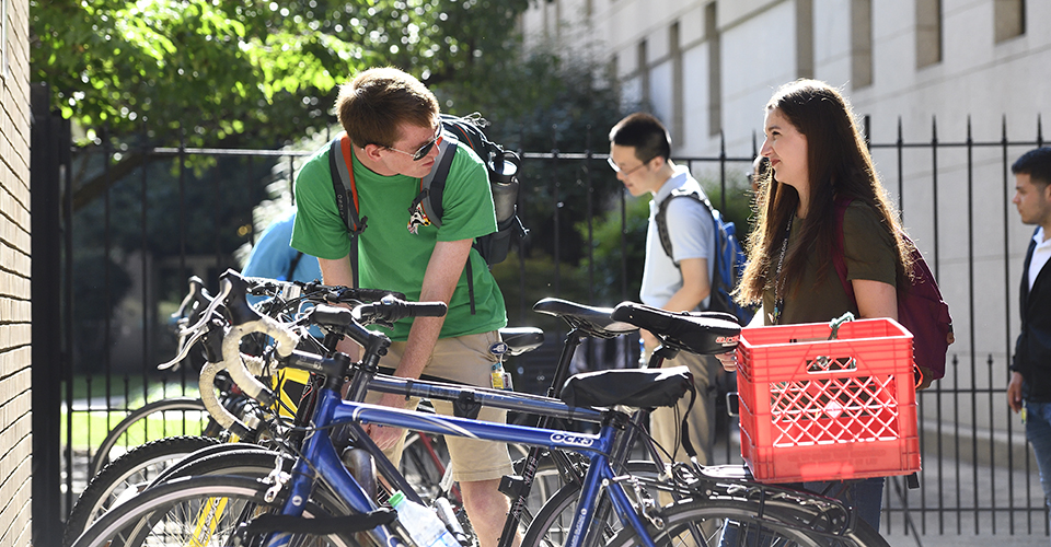 student locking up bike on campus