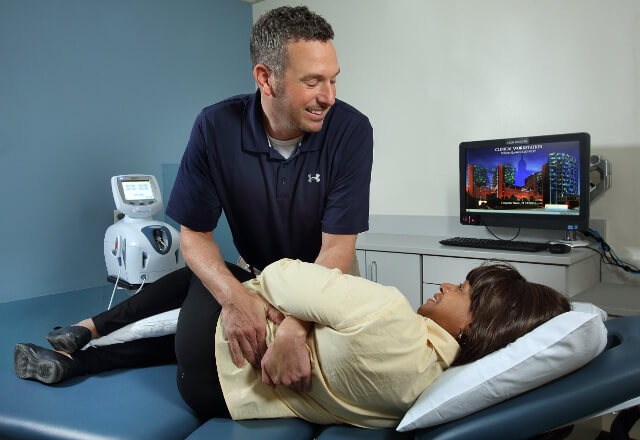 Physical therapist helping patient with back pain.