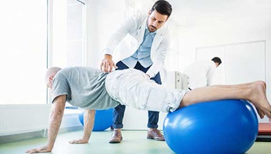 Senior man in physical therapy for back pain