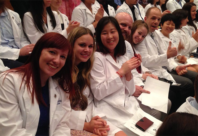 Graduate students celebrate in the audience during the 2016 Graduate Coating ceremony.