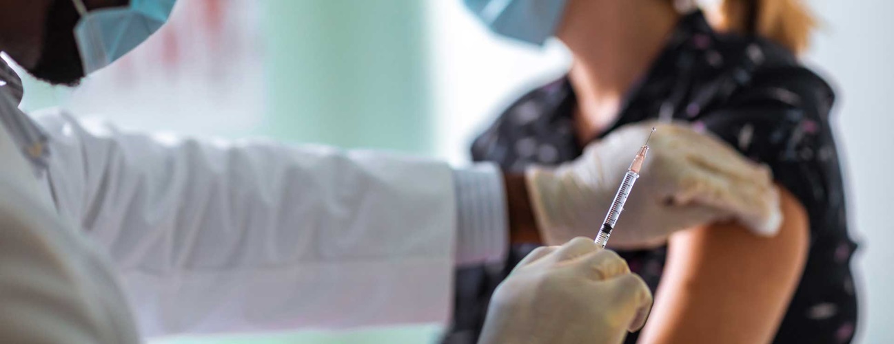 Doctor administering a vaccine to a patient