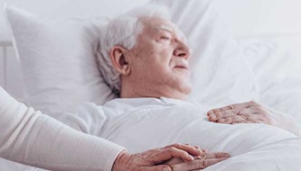 man in bed with a woman's hand holding his