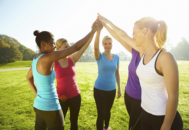 Group of women standing in a circle high-fiving