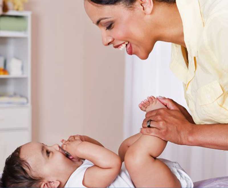 mother and baby smiling on changing table