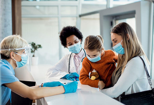 A mother and child check in to the hospital front desk