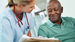 older man consulting with female doctor