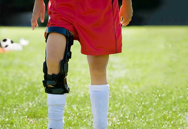 Soccer playing with a knee brace.