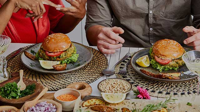 Dinner table with two veggie burgers and toppings